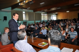 secretário na mesa aponta para os novos diretores, também na mesa