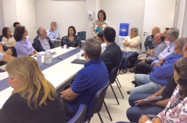Grupo de pesquisadores sentados numa mesa para reunião